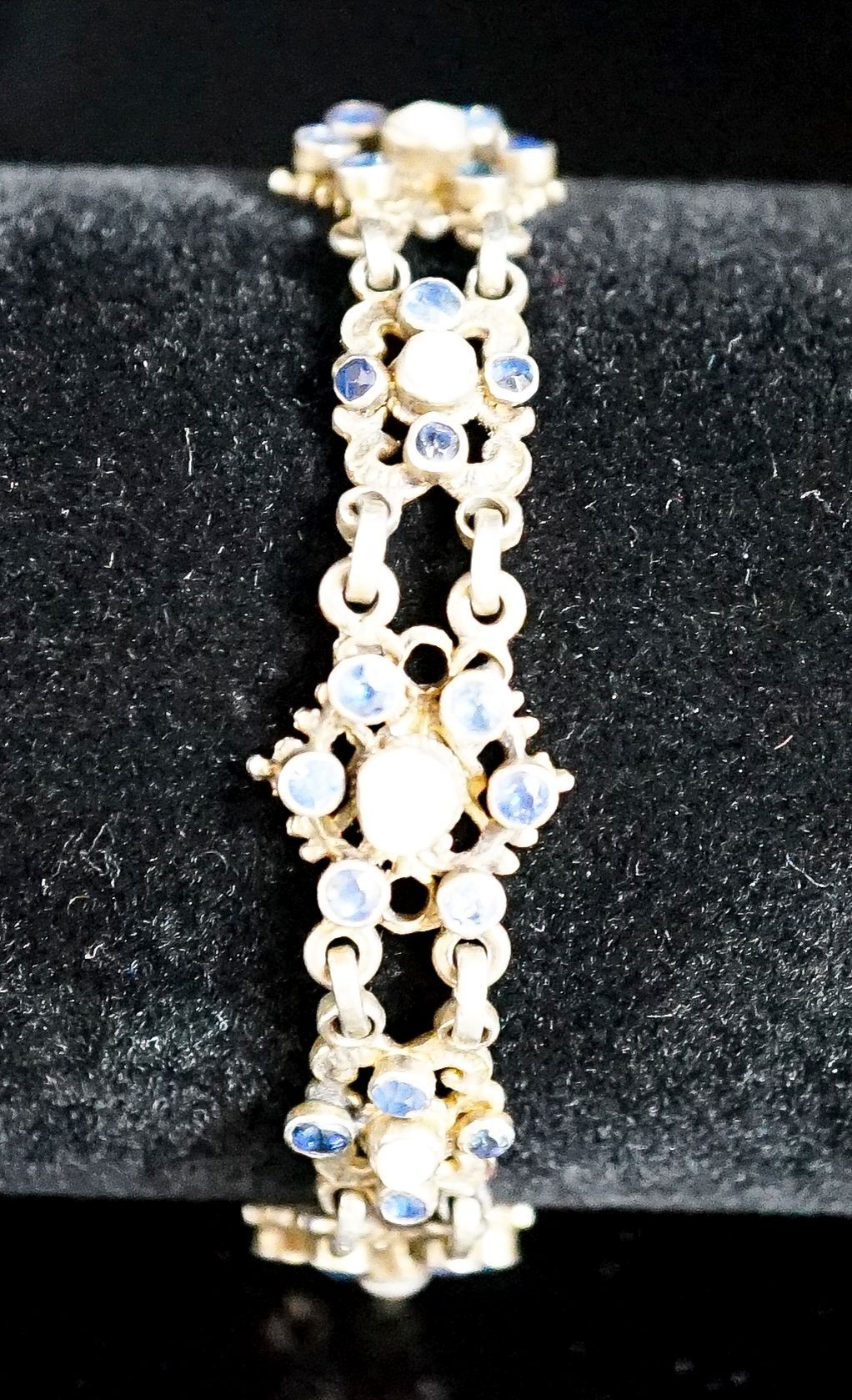 A continental gilt white metal, sapphire and split pearl flower head cluster set bracelet